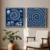 Luxury Warli diptych canvas wall art featuring traditional village life, spiral Tarpa dance motifs, white tribal illustrations, and a deep indigo navy background with black gallery frames.